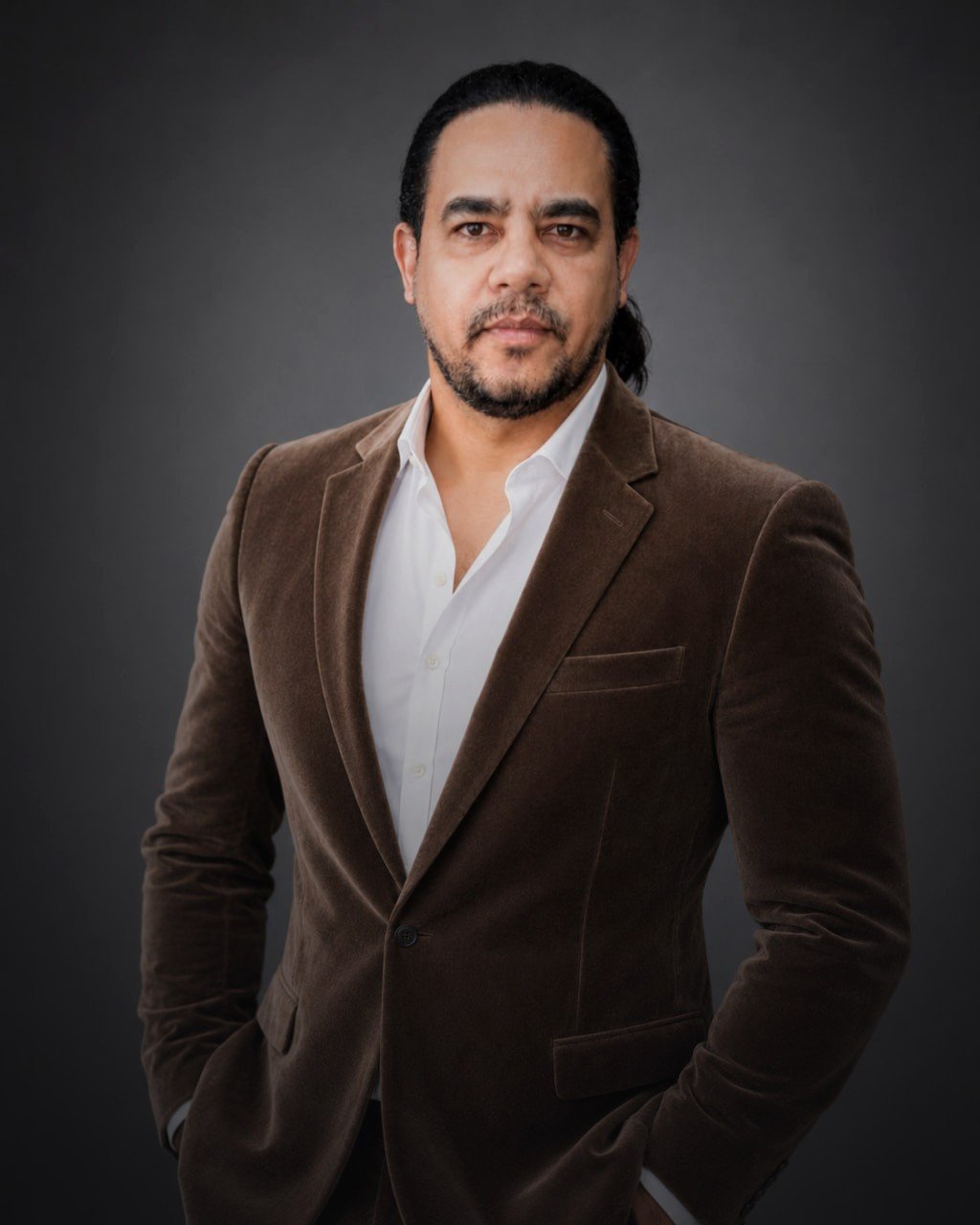 Andre Richest Costa em retrato profissional, blazer marrom